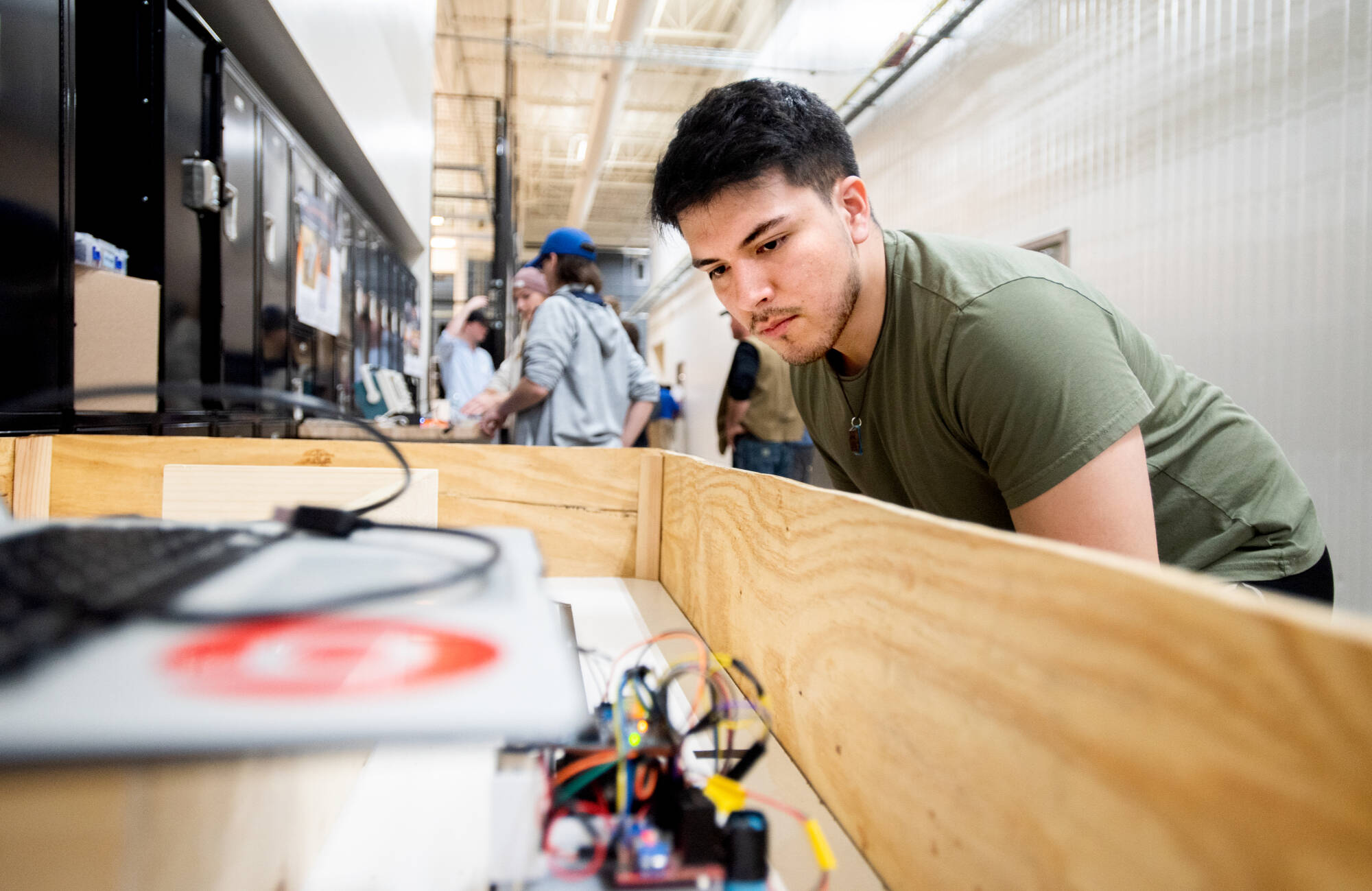 Antonio Santos, a first-year student majoring in product design and manufacturing engineering, looks at his robot, 'Mark."